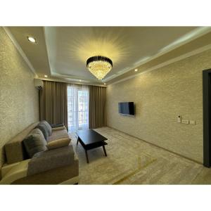 un soggiorno con un divano e un tavolo di Cozy Classic Apartment a Tashkent