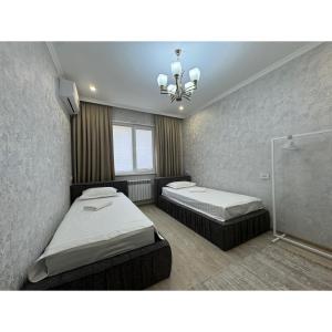 una camera da letto con due letti e un lampadario di Cozy Classic Apartment a Tashkent