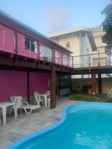 a house with a balcony and a swimming pool at Pousada vila bela in Porto De Galinhas