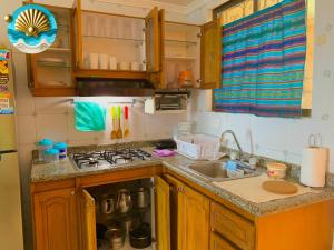 a small kitchen with a sink and a stove at Mar y Sol-El peñón del rodadero in Santa Marta