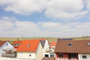a group of houses with orange roofs and a cloudy sky at Velura Apartments Stilvoll in Lauffen am Neckar +11 photos