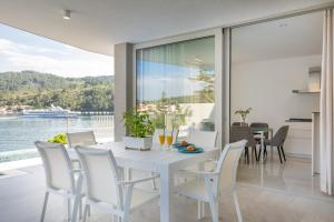 a dining room with a white table and chairs at Villa Maslina in Vela Luka