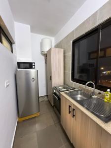 una piccola cucina con lavello e frigorifero di Nexus Lodge a Abidjan Altre 11 foto