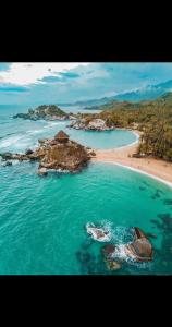 eine Luftaufnahme eines Strandes mit Felsen im Wasser in der Unterkunft Apartamento en santa marta con picsina vía tayrona y palomino in Santa Marta