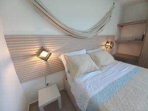Schlafzimmer mit einem Bett und Wandbeleuchtung in der Unterkunft Apartamento en santa marta con picsina vía tayrona y palomino in Santa Marta + 24 Fotos