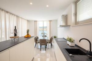 a kitchen with a table with chairs and a sink at Villa Maslina in Vela Luka