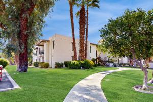 a house with palm trees and a walkway at Sunny Palm Springs Oasis Getaway in Palm Springs