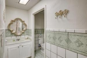 a bathroom with a toilet and a sink and a mirror at 1 Mi to Lake Guntersville Scenic Condo Retreat! in Scottsboro +22 photos