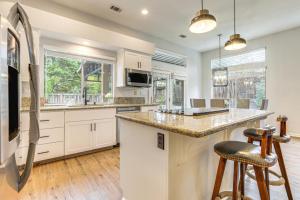 a kitchen with white cabinets and a large island with bar stools at Family Home Near Folsom Lake in El Dorado Hills! in El Dorado Hills