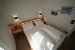 Un dormitorio con una cama blanca con dos luces. en Alaska House Suite Bering - sauna and relax, en Trento