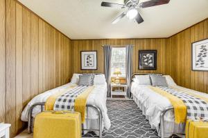 two beds in a room with wooden walls at Scenic East Alabama Retreat on 2 Acres in Lineville +22 photos