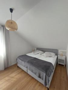 a white bedroom with a large bed and a lamp at Ferienwohnung Senfnest in Ober-Ramstadt