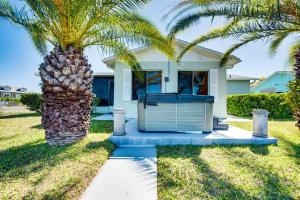 a palm tree in front of a house with a garage at 2 Mi to Beach Canal-Front Home in Hernando Beach in Hernando Beach