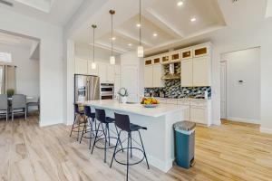 una cucina con armadi bianchi e una grande isola con sgabelli da bar di Sea Clarity a Port Charlotte