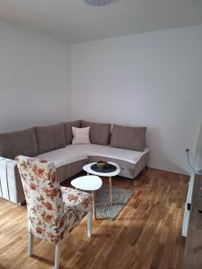 a living room with a couch and a table and a chair at Apartman ZID in Smederevska Palanka