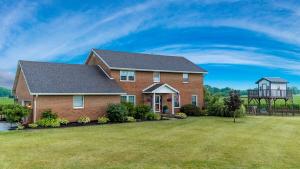 a large brick house with a large yard at The Estate on 68 AND Pet Friendly in Springfield