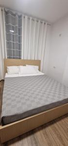 a large bed in a room with a large window at Comfortable holiday apartament in Golem