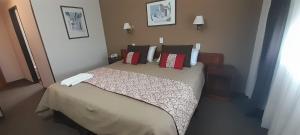 Un dormitorio con una cama grande con almohadas rojas. en Los Acantilados Hotel, en Puerto Deseado