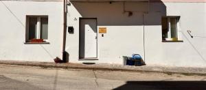 a white building with a door and two windows at Stanza Angeli in Nulvi