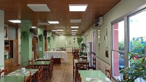 a restaurant with green tables and chairs and a table with a tablecloth at Hotel La Caravella in Bellaria-Igea Marina
