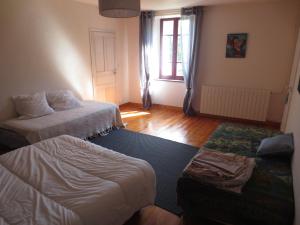 a living room with two beds and a couch at Gite Les Arrebourits 4 étoiles in Anères