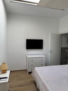 a bedroom with a bed and a flat screen tv at Oasibellavista in Cavo