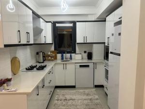 Una cocina blanca con gabinetes y electrodomésticos blancos. en Villa Gülce, en İncirköy