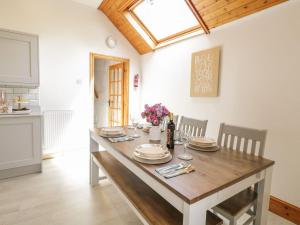 d'une cuisine avec une table avec des assiettes et des fleurs. dans l'établissement Cyffdy Cottage - Tegid, à Bala 18 autres photos