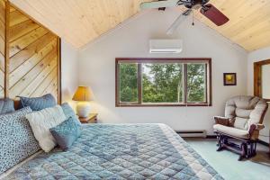 Un dormitorio con una cama y una silla y una ventana. en Skyleaf 404, en Sugar Mountain