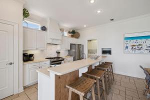 a kitchen with white cabinets and bar stools at Always On My Mind by 30A Escapes in Seacrest +42 photos