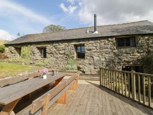 a wooden bench in front of a stone building at Cyffdy Cottage - Arenig in Bala