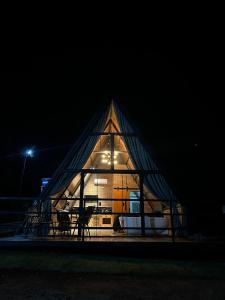 a largeangular building with a window in the night at Cabana Recanto nas Montanhas in Lindóia