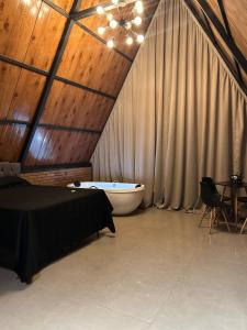a bedroom with a bath tub and a ceiling at Cabana Recanto nas Montanhas in Lindóia
