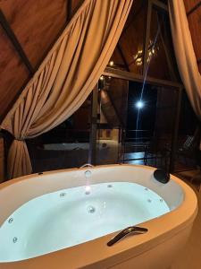 a bath tub in a room with a light at Cabana Recanto nas Montanhas in Lindóia