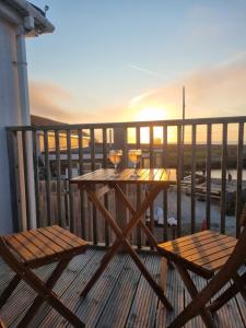 a table with two glasses of wine on a balcony at Sandy Paws in Portreath +4 photos