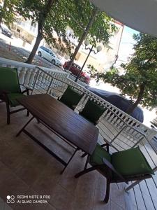 a wooden bench and chairs on a patio at JnB in Paralia Katerinis