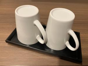 two white mugs sitting on a black tray at Smile Hotel Okayama - Vacation STAY 60155v in Okayama +24 photos