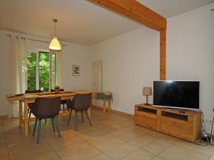 a living room with a television and a table with chairs at Ferienhaus Barbara, Zarrentin in Zarrentin