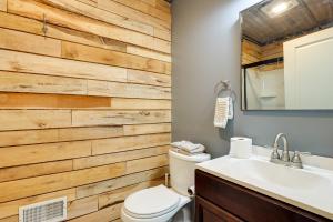 a bathroom with a wooden accent wall at Spacious Canandaigua Group Getaway House and Barn! in Honeoye +37 photos