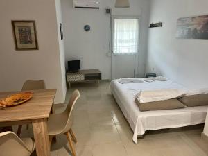 una camera da letto con un letto e un tavolo con sedie di 3 Bedroom House, 200m from Trikorfo Beach a Yerakiní