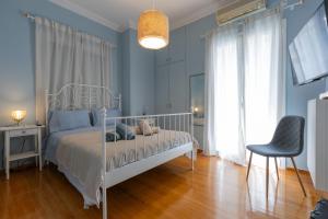 a bedroom with a white bed and a chair at Casa di Mare Air-bnb in Nafpaktos