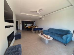 a living room with a blue couch and a table at Villa neuve avec piscine in Régusse