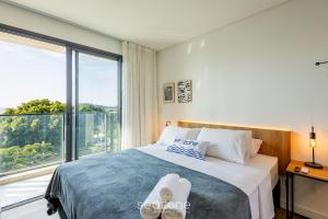 a bedroom with a bed and a large window at Estúdios c/ Vista Frente Mar no Penha Spot | PSO - VF in Gravata +177 photos