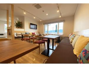 a living room with tables and chairs and a couch at Hotel Hanafuji Inn - Vacation STAY 82497v in Nakafurano