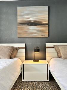 a bedroom with two beds and a table with a lamp at La Villa LIFE in La Plaine des Palmistes