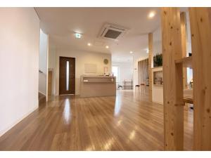 an empty living room with wooden floors and a kitchen at Hotel Hanafuji Inn - Vacation STAY 82494v in Nakafurano