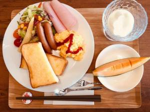 a plate of food with sausage bread and a sandwich at Hotel Hanafuji Inn - Vacation STAY 82494v in Nakafurano +11 photos