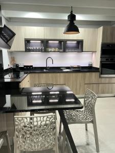 a kitchen with a table and two chairs and a sink at La Villa LIFE in La Plaine des Palmistes