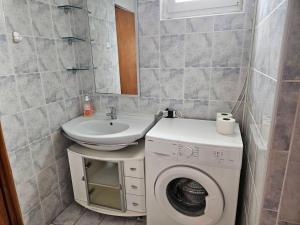 a bathroom with a washing machine and a sink at Apartmani Štefica in Dramalj +42 photos