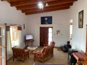 una sala de estar con sillas y una mesa en Casa La Bustamante, en El Mollar